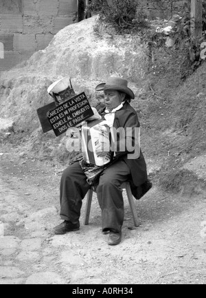 'Foi' artiste de rue homme jouant et collecter de l'argent dans l'entonnoir sur le dessus de son accordéon Bogota Colombie Amérique Latine du Sud Banque D'Images