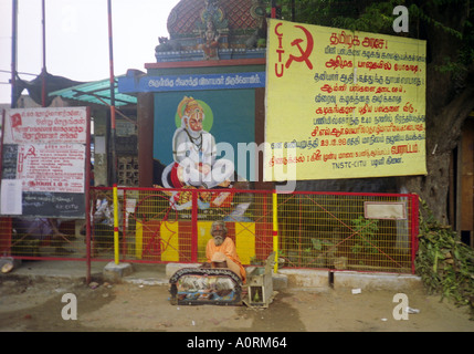 Barbe blanche sage sénile de l'homme hindou typique en vêtements colorés siéger par grand signe communiste Palani Tamil Nadu Inde Asie du Sud Banque D'Images