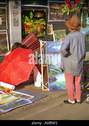 Artiste de rue femme afficher des tableaux colorés à l'extérieur du marché Anusan trottoir occupée Chiang Mai Thaïlande Asie du sud-est Banque D'Images