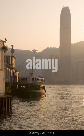 Dh Terminal star Ferry Tsim Sha Tsui Hong Kong jetée Pier bâtiment central de la SFI silhouette au coucher du soleil port skyline Banque D'Images