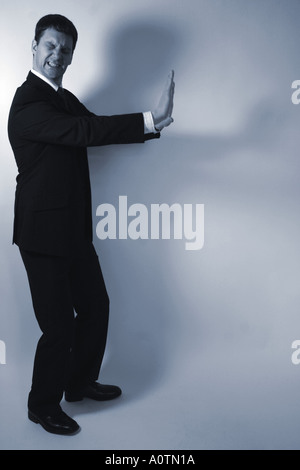 Image homme d'affaires conceptuel montrant poussant quelque chose qui n'est pas là Banque D'Images