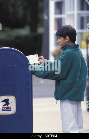 Asian American boy lettre postale dans la boîte aux lettres Banque D'Images