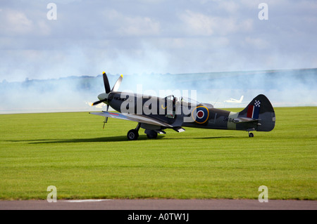 Spitfire Mk 18 SM845 atterrissage à l'aérodrome de Duxford avec de la fumée à l'arrière-plan Banque D'Images