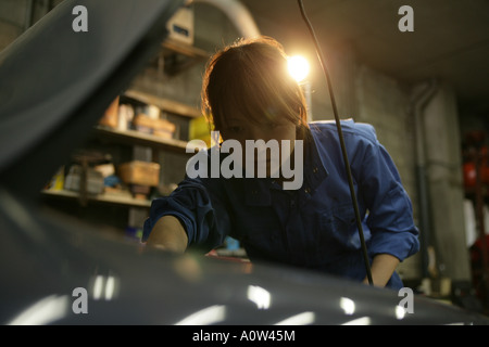 Close-up of auto mechanic examiner un moteur Banque D'Images