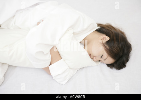 Portrait d'une jeune femme dormir avec un oreiller Banque D'Images