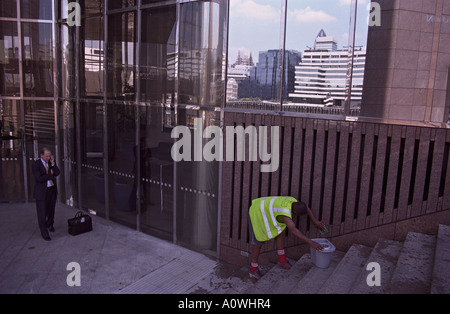 Royaume-uni, Angleterre, Londres. Chef d'entreprise à l'aide de téléphone mobile et plus propres au travail de rue dans la ville Banque D'Images