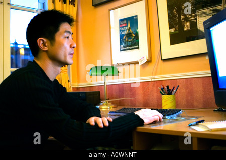 Portrait jeune Chinois, Homme étudiant travaillant, regardant l'écran d'ordinateur la nuit seule personnes seules travaillant sur MAC Banque D'Images