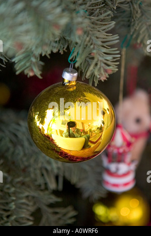 En verre jaune bauble hanging sur un arbre de Noël vert Banque D'Images