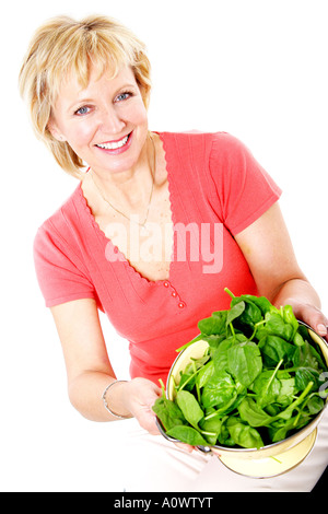 Mature Woman Holding passoire d'épinards Parution Modèle Banque D'Images