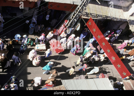 Les hommes et les femmes dans des châles et vêtements de mousseline au marché du tapis de Rabat Maroc Banque D'Images