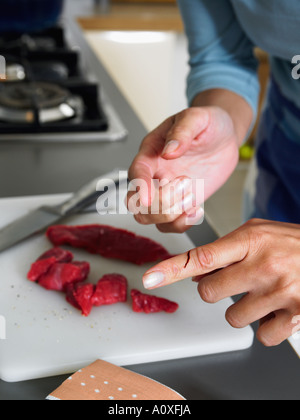 Femme en cuisine avec cut sur son doigt Banque D'Images