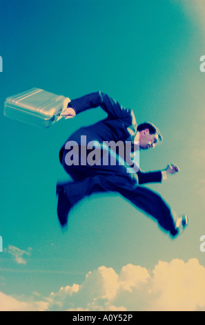 Low angle view of a businessman carrying a briefcase in mid-air Banque D'Images