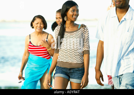 La famille africaine élargie la marche sur la plage ensemble Banque D'Images