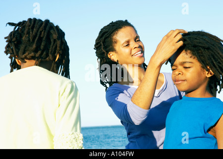 Femme africaine fixant les cheveux de son fils Banque D'Images