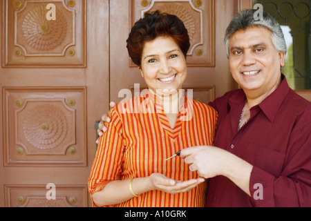 Portrait d'un homme mûr donnant à ses clés de voiture pour une femme mature Banque D'Images