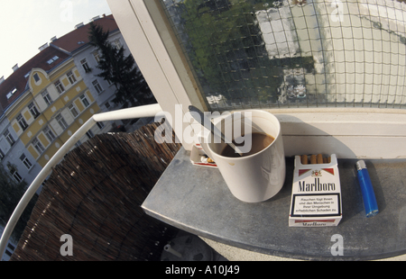 Tasse de café, les cigarettes de Marlboro, plus léger sur un balcon de la ville Banque D'Images