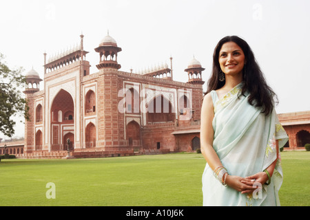 Portrait d'une jeune femme debout en face d'un mausolée, le Taj Mahal, Agra, Uttar Pradesh, Inde Banque D'Images