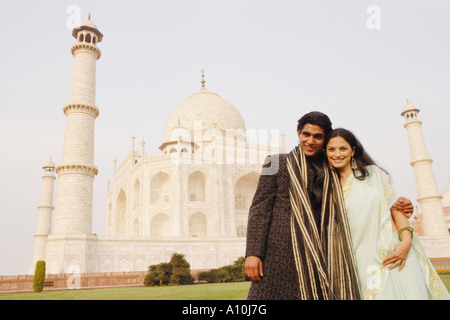 Jeune couple debout devant un mausolée, le Taj Mahal, Agra, Uttar Pradesh, Inde Banque D'Images