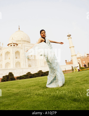 Portrait d'une jeune femme debout en face d'un mausolée, le Taj Mahal, Agra, Uttar Pradesh, Inde Banque D'Images