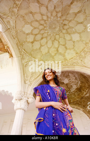 Low angle view of a young woman smiling, fort d'Agra, Agra, Uttar Pradesh, Inde Banque D'Images