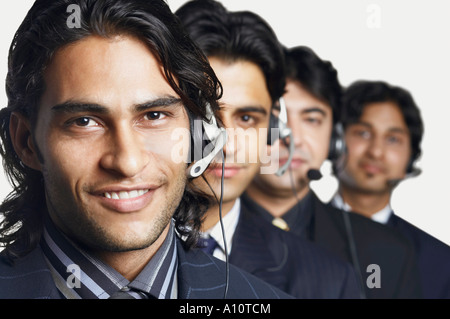 Portrait de quatre représentants du service à la clientèle d'hommes portant des casques Banque D'Images