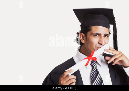 Portrait d'un homme embrassant son diplôme d'études supérieures Banque D'Images