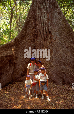 Les gens de la famille de touristes posant pour photographier en face d'acajou dans le parc national de Tikal, dans la région de El Peten à El Peten au Guatemala Ministère Banque D'Images