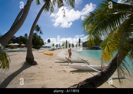 Outrigger bateaux & les gens sur la plage, le Pearl Beach Resort, Bora Bora. Banque D'Images