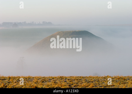 Silbury Hill monument néolithique mystérieux dans le Wiltshire enveloppées de brumes au petit matin Banque D'Images