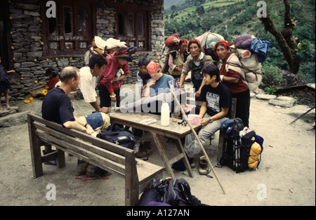 Un groupe de trekkeurs contrôle la carte tout en un groupe de commerçants tibétains semble sur, dans la région de Khumbu Sollu de l'Himalaya, Népal Banque D'Images