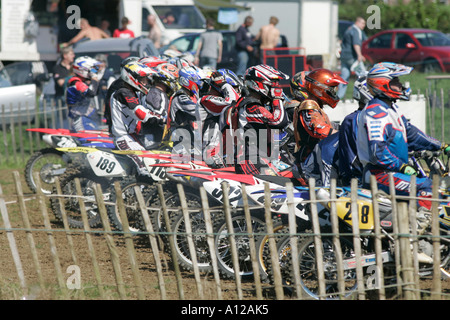 Les concurrents s'alignent sur la grille de départ derrière une clôture en bois à tandragee circuit de motocross le comté de Down en Irlande du Nord Banque D'Images