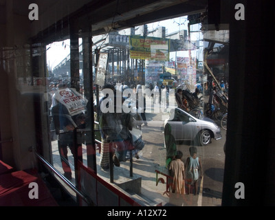 Le chaos de Dhaka urbain vu dans le reflet dans une vitrine Banque D'Images