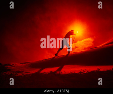 La fondeuse plods montée en fin de journée et est découpé sur la couleur chaude du soleil couchant Banque D'Images