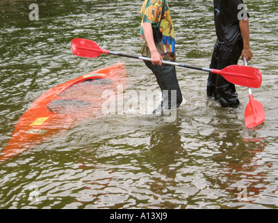 Canot creux avec deux personnes debout dans l'eau jusqu'aux genoux Banque D'Images
