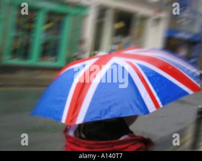 La recherche d'abri de la pluie sous parapluie Union Jack Banque D'Images