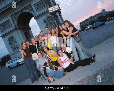 Un groupe d'étudiants posant devant l'Arc de Triomphe Paris France au crépuscule Banque D'Images