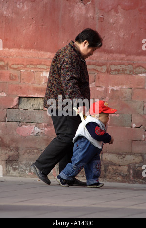 Petit-fils marche avec l'aide de grand-mère au Parc Jingshan, Beijing, Chine Banque D'Images