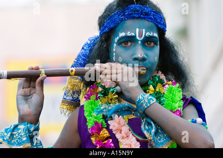 Portrait du jeune Indien street performer habillé comme Le Seigneur Krishna jouant de la flûte. Puttaparthi, Andhra Pradesh, Inde Banque D'Images