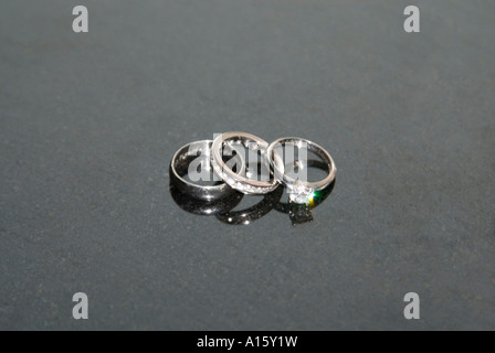 L'horizontale de près de l'époux et l'épouse et des bandes de mariage de platine du bride's bague de fiançailles en diamants sur un fond noir. Banque D'Images