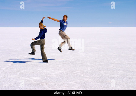 Amis jouant sur Salar de Uyuni, Bolivie Banque D'Images