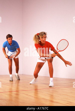 Attractive young couple playing racquetball Banque D'Images