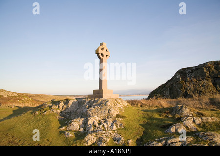L'ÎLE LLANDDWYN ISLE OF ANGLESEY AU NORD DU PAYS DE GALLES Décembre fin de soirée soleil projette une lueur chaude sur la croix celtique Banque D'Images