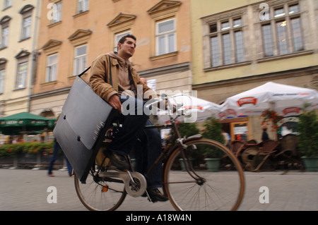 Vie quotidienne à Cracovie Pologne un étudiant d'art avec ses promenades en portefeuille de l'autre côté de la place du marché Rynek Glowny Banque D'Images