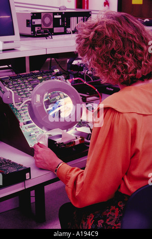 Femme à l'aide de loupe l'essai du calculateur CA Banque D'Images