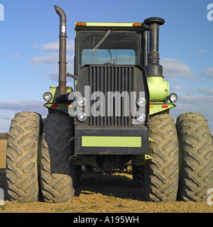 Un tracteur agricole vert contre le ciel bleu Banque D'Images