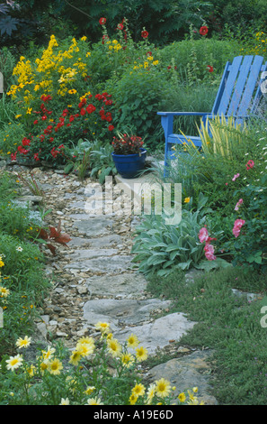 Jardin privé : chemin mène à travers des dalles en fleurs colorées accueil jardin fleuri avec bois bleu chaise Adirondack, New York USA Banque D'Images
