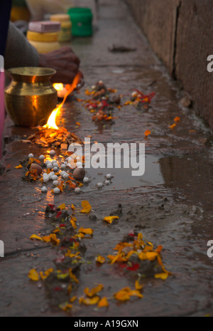 L'Uttar Pradesh Inde Gange valley Varanassi Kedar ghat au lever du soleil près de pétales de fleurs et le feu sur un ghat s étape comme une relig Banque D'Images
