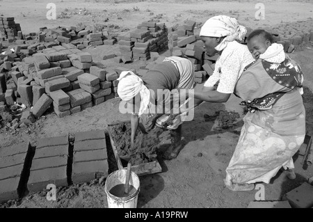 B/W des réfugiés rapatriés qui ont fui au Zimbabwe pendant la guerre civile en faisant des briques pour reconstruire leurs maisons dans un Mozambique pacifique et établi Banque D'Images