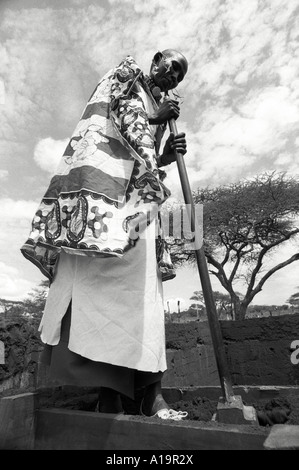 B/W d'une femme Maasai dans la construction traditionnelle de robe une terre rammed adobe maison, une nouvelle technique pour les bâtiments plus durables.Kajiado, Kenya Banque D'Images