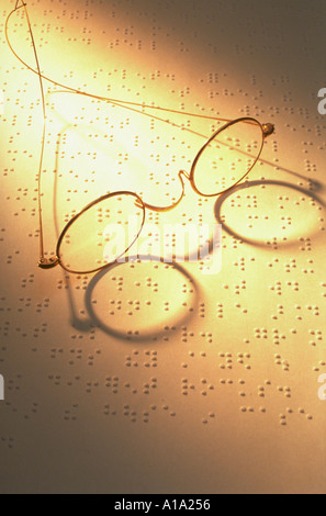 La vie encore d'une paire de lunettes rim fil assis sur une page de braille Banque D'Images